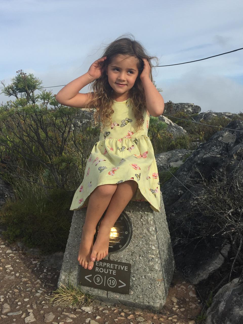 Mica on a rock in a butterfly dress