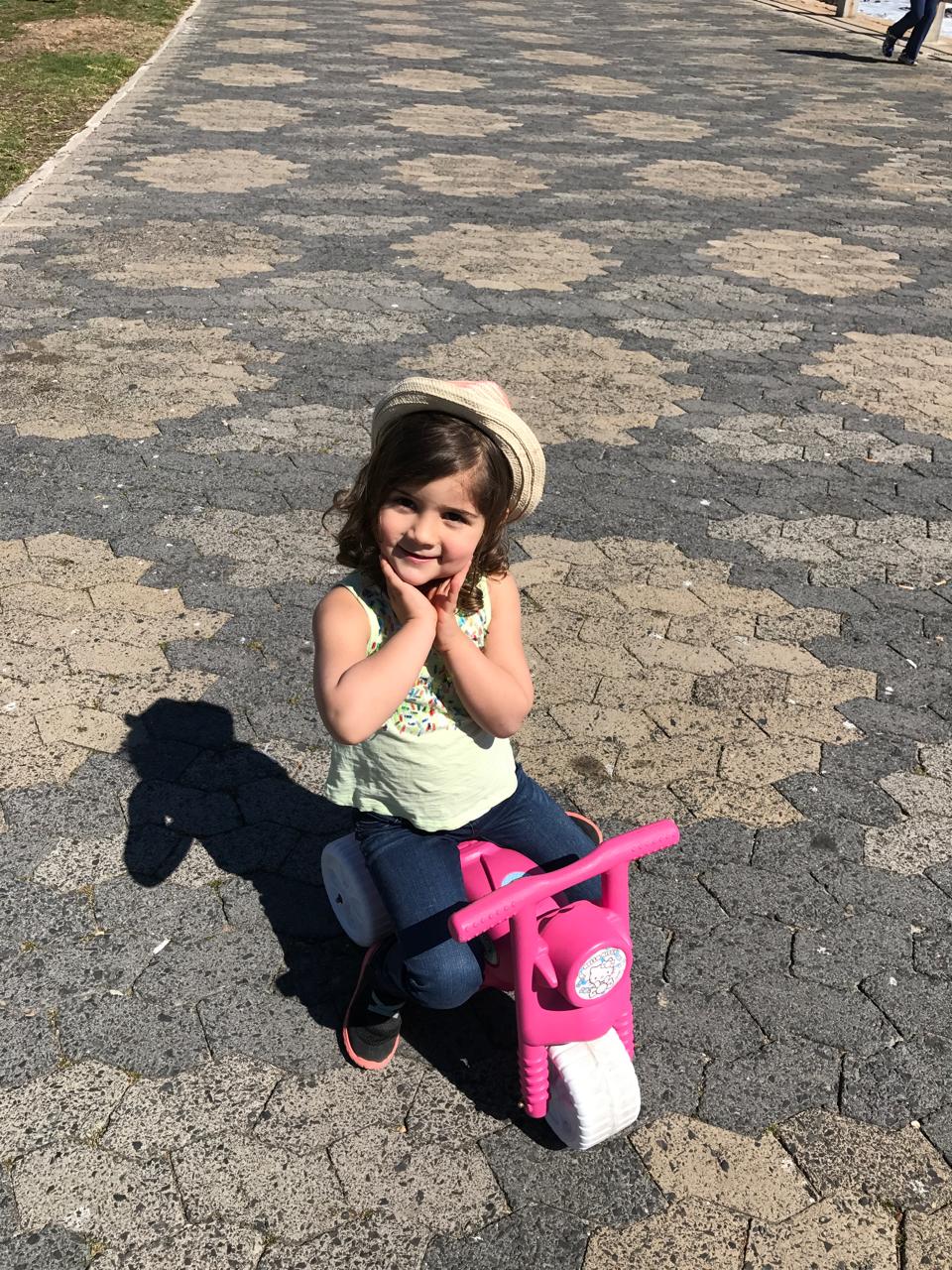 Mica being adorable on a pink scooter