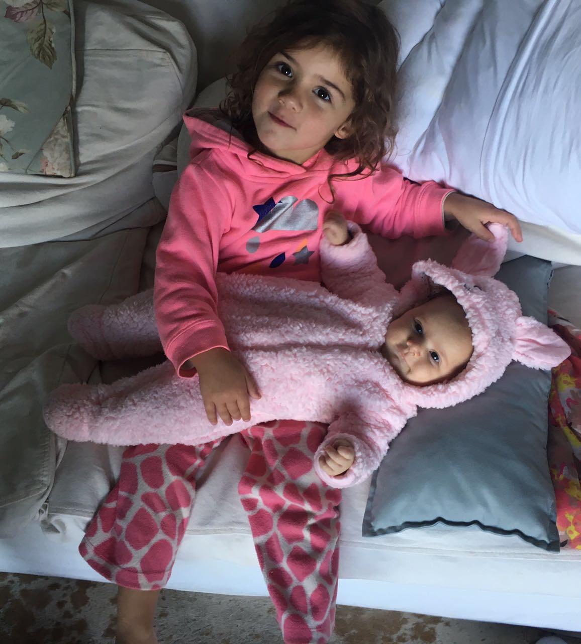 Mica cuddling baby sister