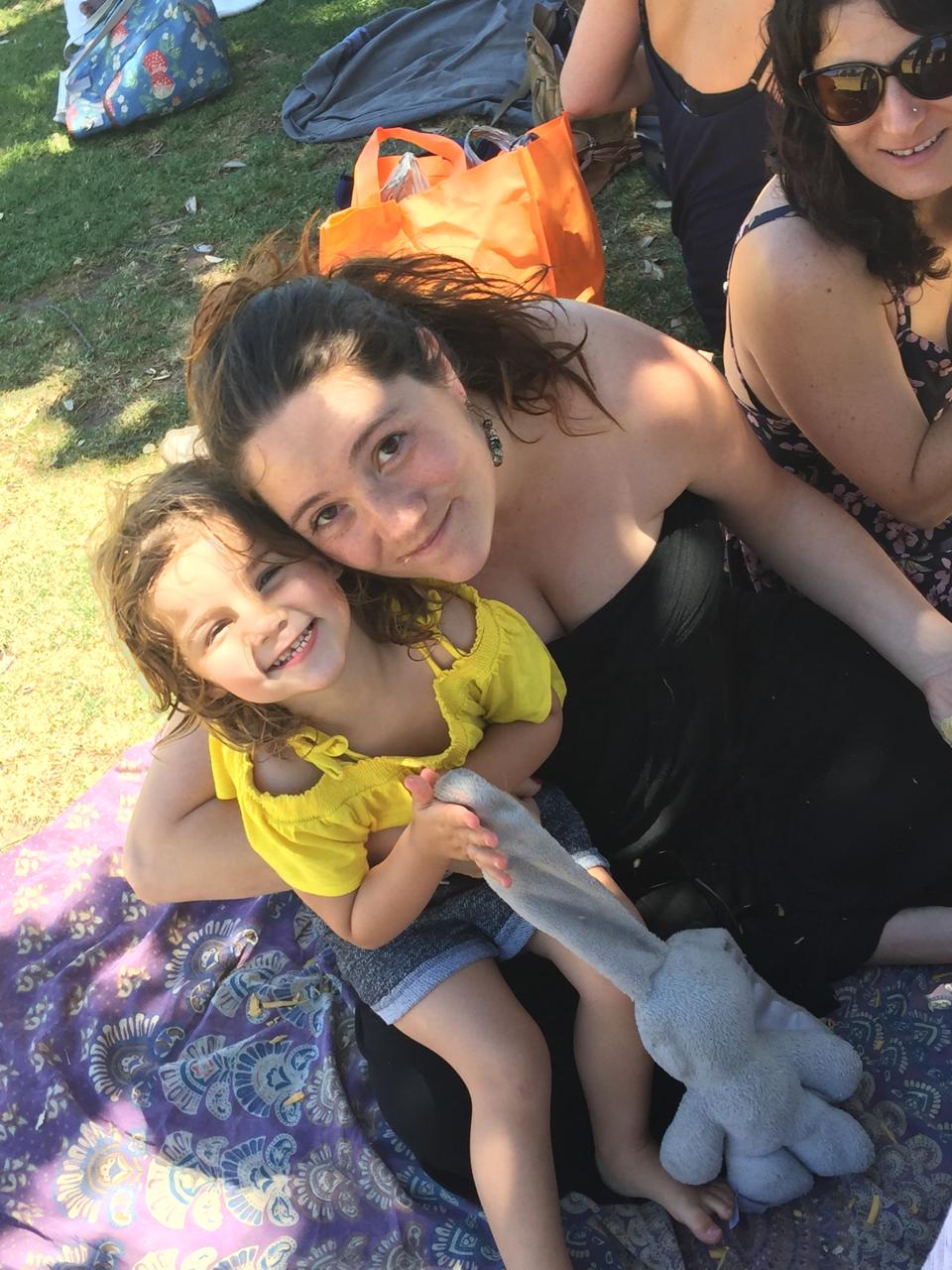 Mica giggling with Mom at a picnic
