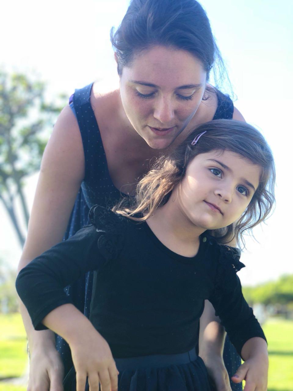 Little Mica leaning on Mom in the park