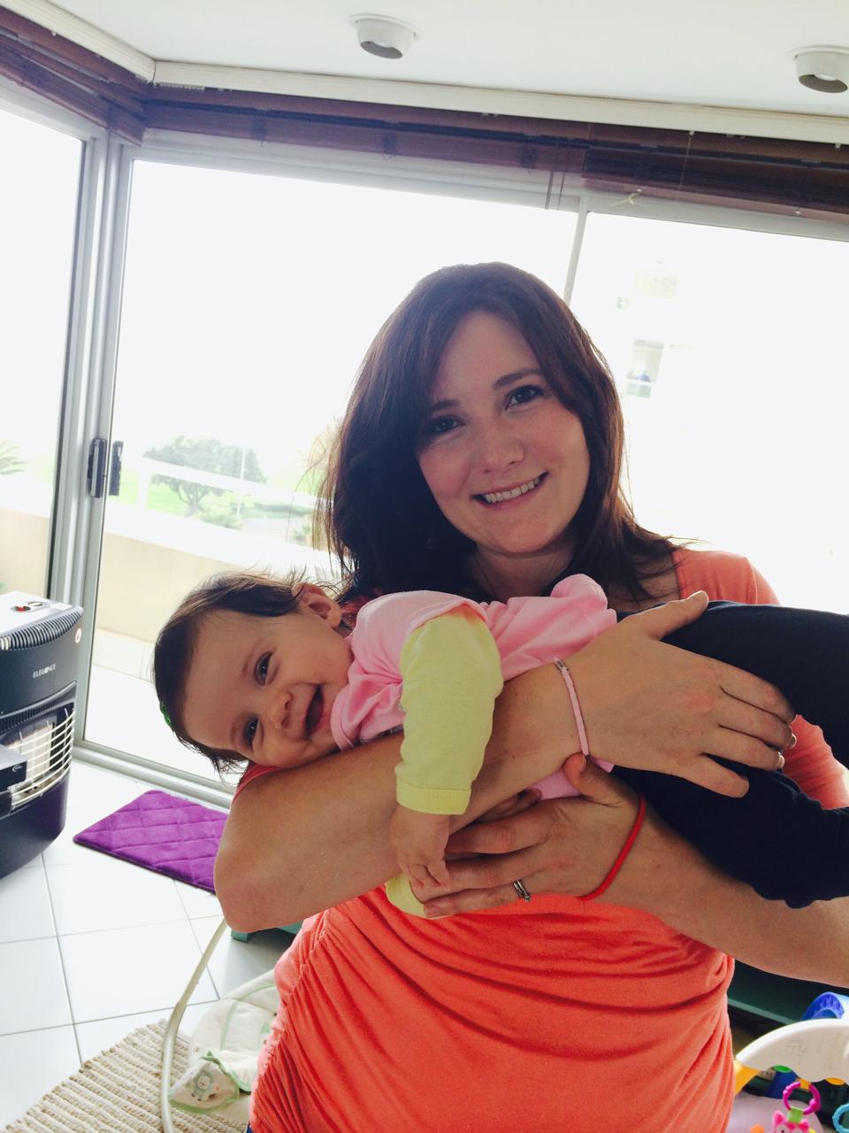 Mom holding baby Mica by the window